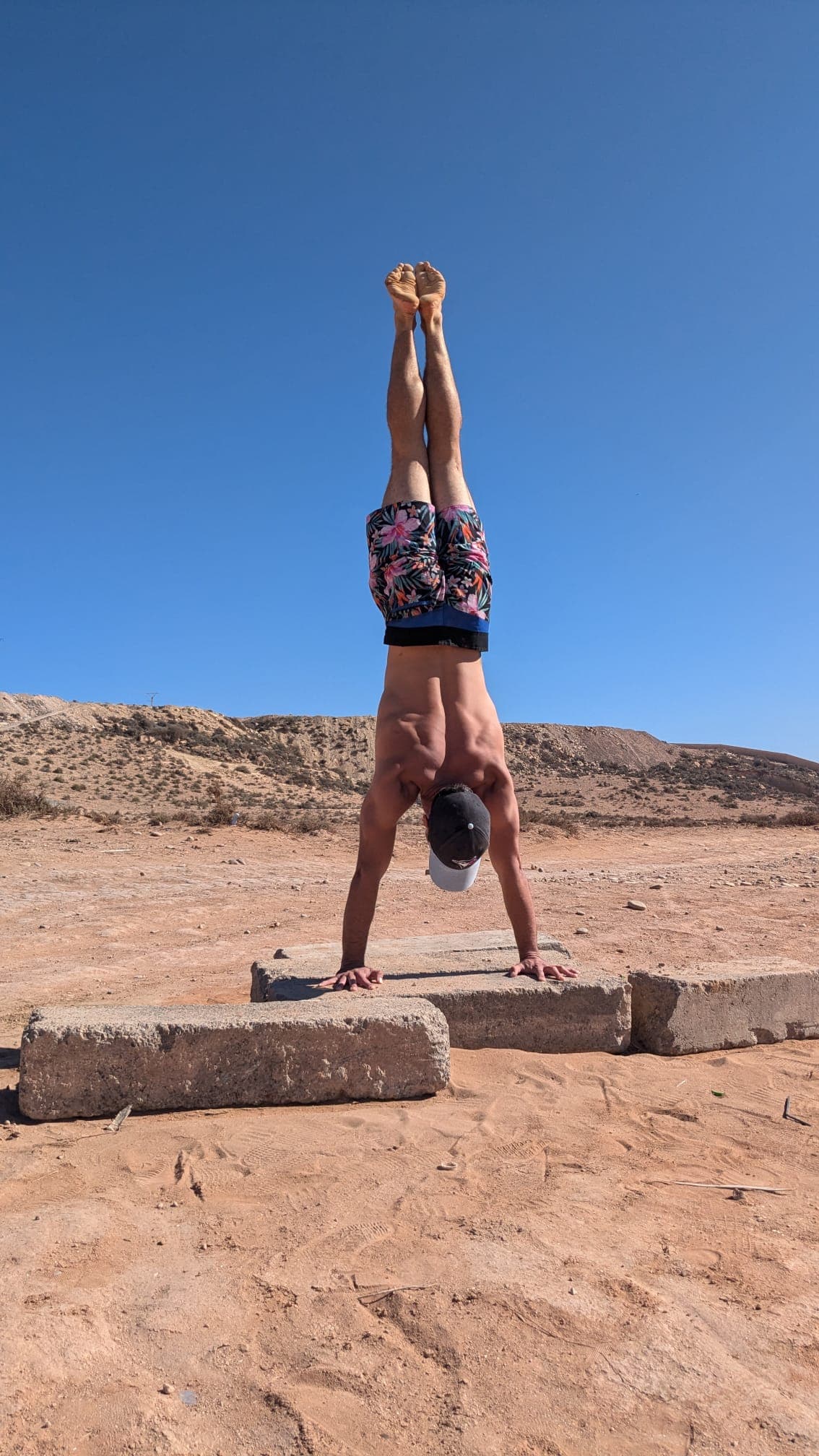 Handstand on concrete blocks in a red desert landscape