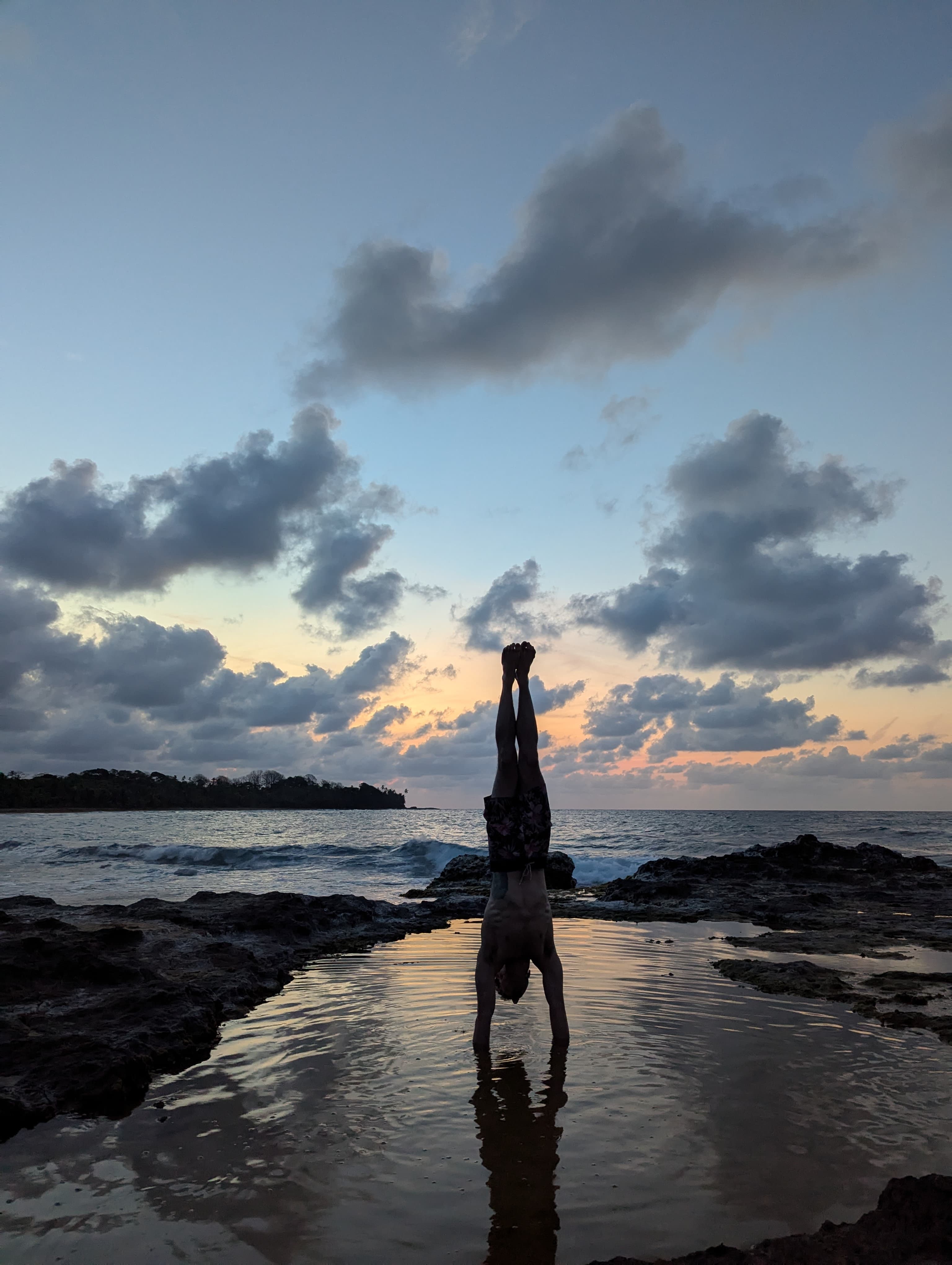Silhouette handstand in a Panama tidal pool at sunset