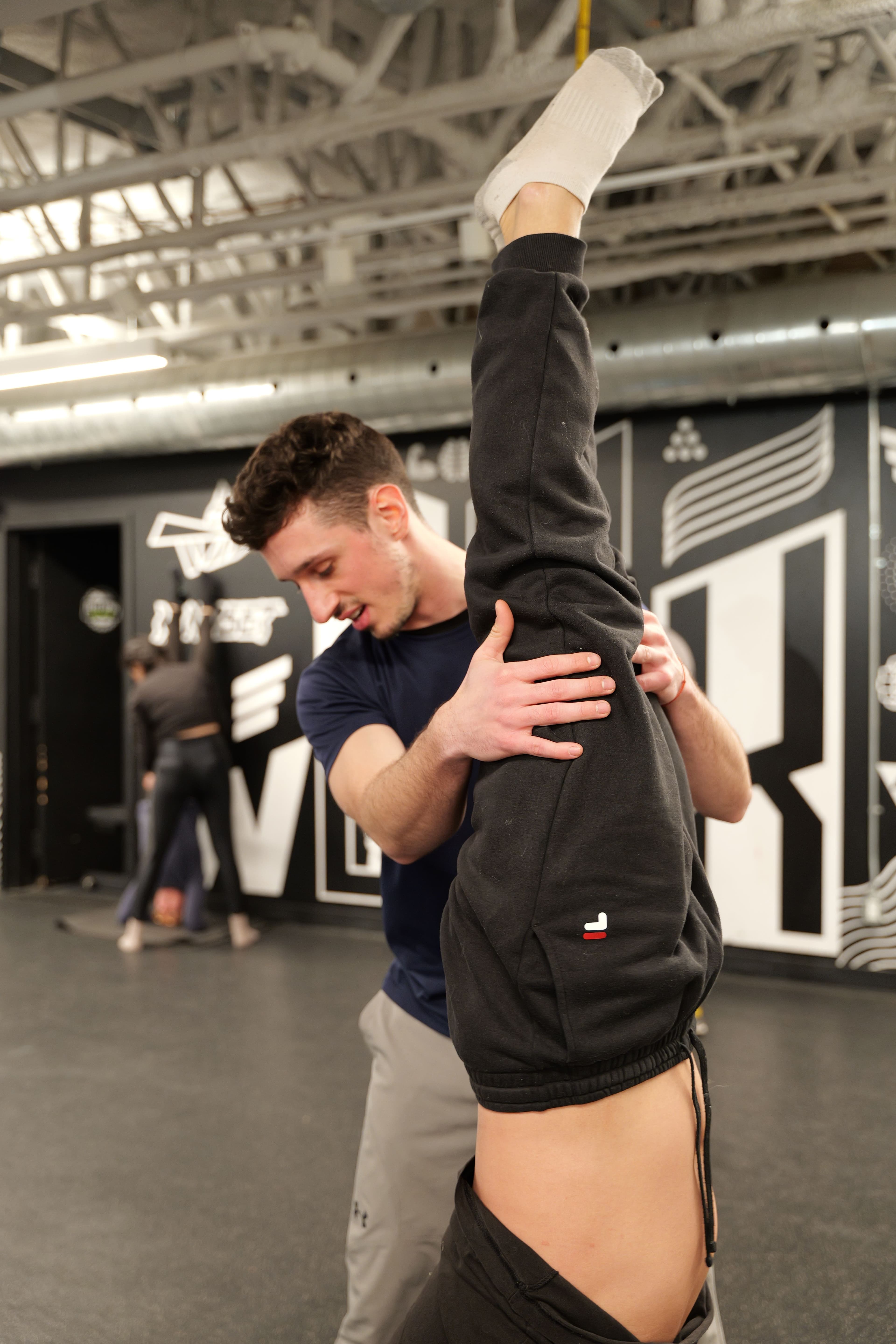 Jonny close up spotting a handstand, focused and present