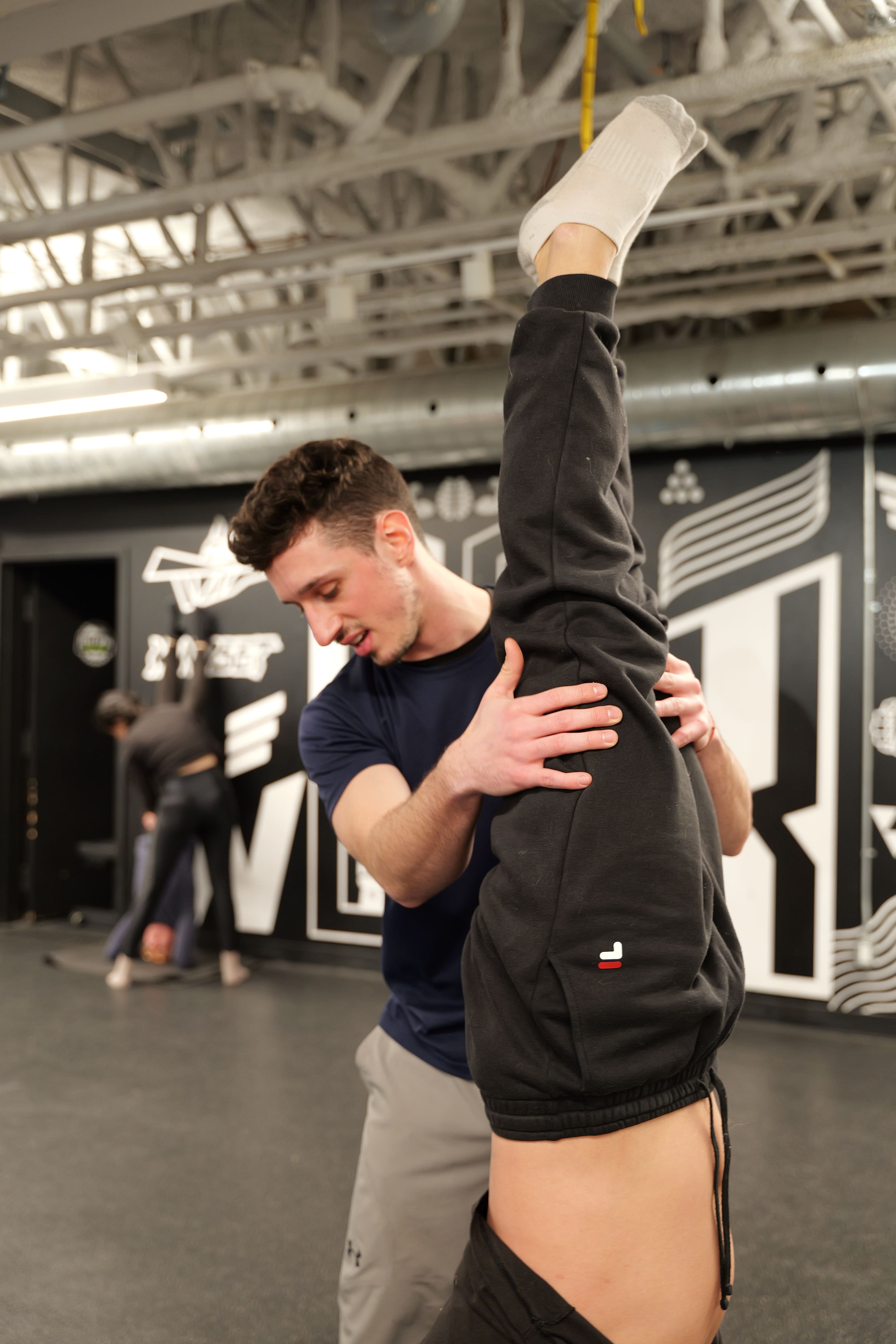 Jonny hands-on spotting a handstand, total focus
